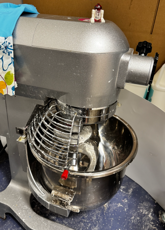 Large industrial mixer with a metal bowl on a countertop